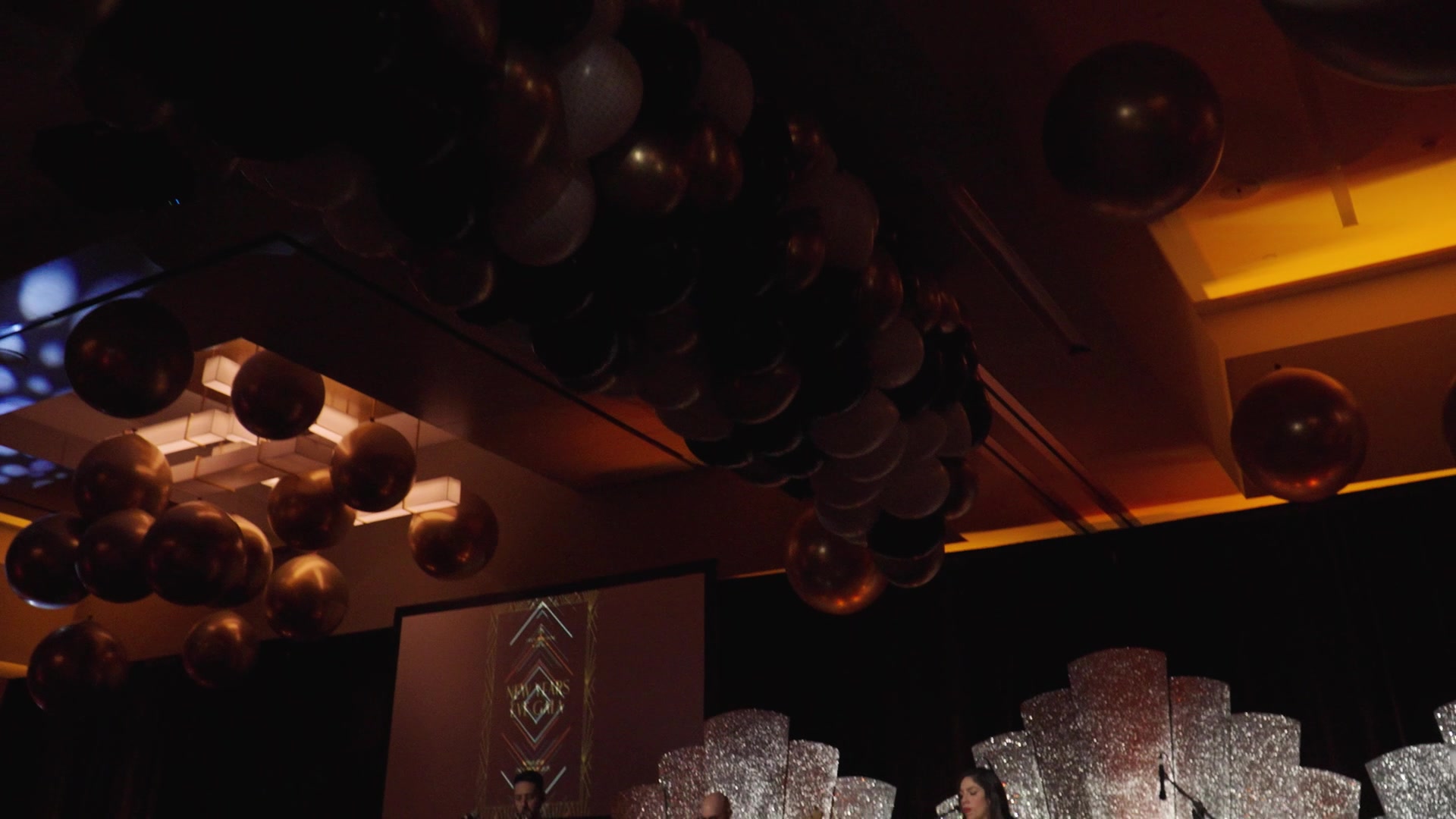 Gold and black balloon drop cascading from the ballroom ceiling at the Four Seasons New Year's Eve gala