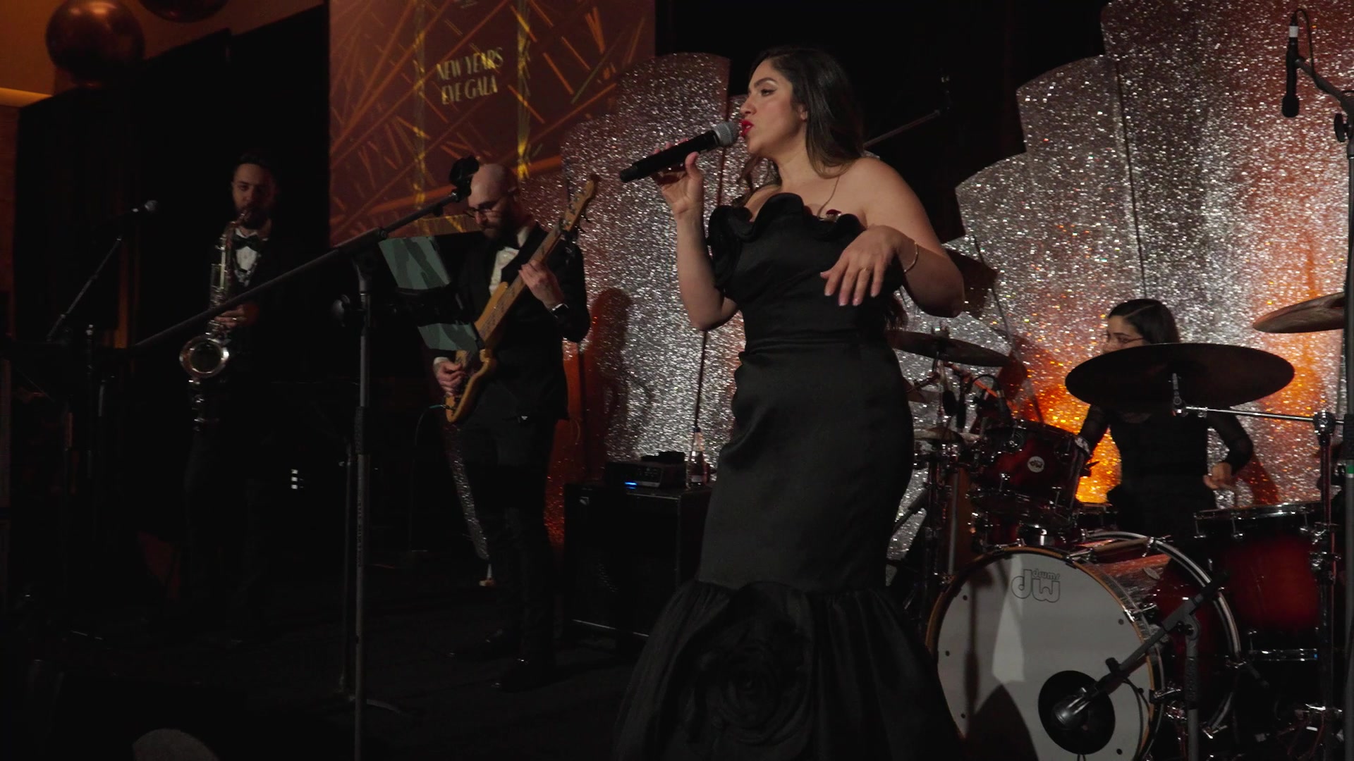 Sunny Jazz Band performing with vocalist in a black gown against a silver Art Deco sunburst backdrop