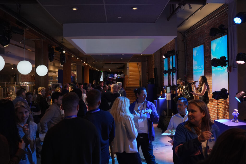Guests mingling at a Los Angeles cocktail reception while the Sunny Jazz Band local jazz duo performs live